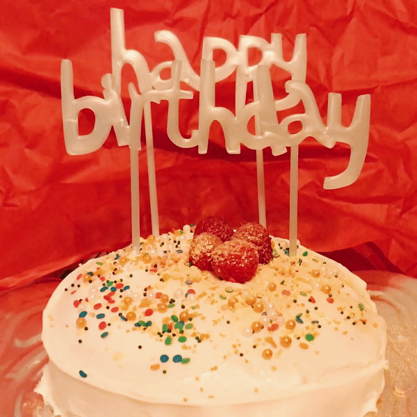 GIF of a 'Happy Birthday' cake, that explodes (edible) glitter as it is sliced with a knife.